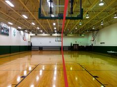 an indoor basketball court with hard wood flooring