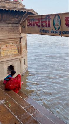 a person sitting on the ground near water