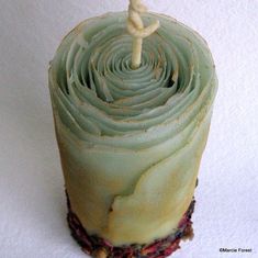 a green frosted cupcake with a single candle on it's top that is shaped like a spiral