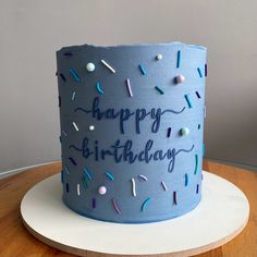 a blue birthday cake with sprinkles on it