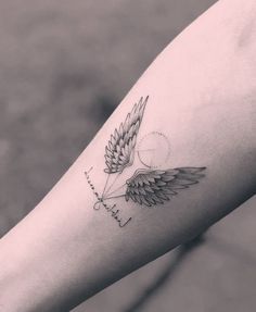 a person with a tattoo on their arm that has wings and the word faith written in cursive writing