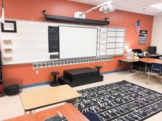 an empty classroom with desks, chairs and a whiteboard on the wall in front of it