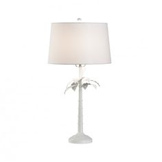 a table lamp with a white shade on the top and palm trees on the bottom