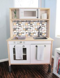 a toy kitchen with sink, stove and microwave