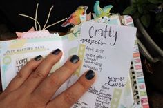 a woman's hand holding onto a paper with writing on it