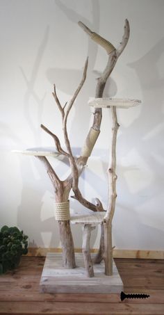 a sculpture made out of driftwood on a wooden table next to a potted plant