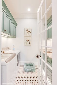 a white bathroom with green cabinets and a black and white checkered tile flooring