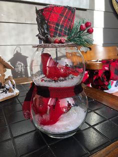 a glass fish bowl filled with snow and decorations