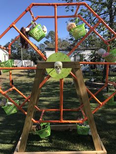 a wooden structure with green and orange decorations on it's sides in the grass