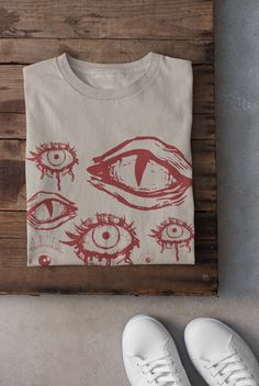 Thanks for stopping by! Eyes Alternative T-shirt Printed on a super soft, cotton tee Dispatched in 5 working days or sooner Unisex Free UK delivery Material: 100% ringspun cotton. Chest (to fit): S  34/36   M  38   L  40/42   XL  44/46   XXL  48/50 ECO-FRIENDLY Each garment is made to order, reducing extra material and energy that would be otherwise wasted We use DTG printing process which is easier on the environment than screen-printing Our ink is bright and also eco-friendly. Do not tumble dr Womans Graphic Tee, Alternative Tshirts, Horror Graphic Print Top For Alternative Fashion, Cryptid Outfit, Alternative Style Cotton T-shirt With Back Print, Grunge Cotton T-shirt With Front Print, Emo Style Cotton T-shirt With Graphic Design, Grunge Cotton T-shirt With Character Print, Alternative Shirts