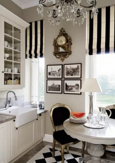 a kitchen with black and white checkered flooring, chandelier above the dining room table