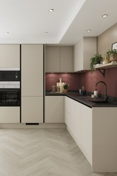 a modern kitchen with white and beige cabinets, black counter tops, and wood flooring