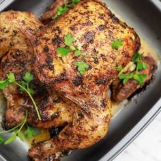 a close up of a chicken in a pan with garnishes on it