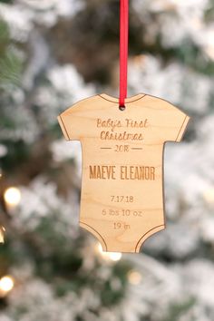 a baby's first christmas ornament hanging from a tree