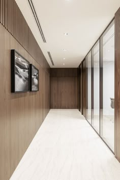 an empty room with wood paneling and two framed pictures on the wall next to it