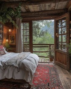 a bed in a room with lots of windows and rugs on the floor next to it