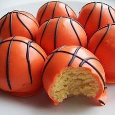 several orange basketballs are on a plate with chocolate drizzled around them