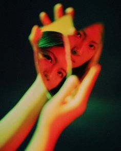 two people holding up their hands to show the reflection of them in front of a mirror