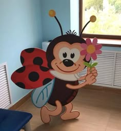 a paper cut out of a ladybug holding a flower