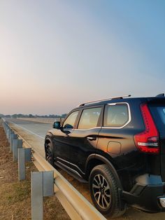 an suv is parked on the side of the road next to a highway divider