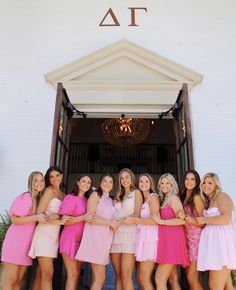 a group of women standing next to each other in front of a building