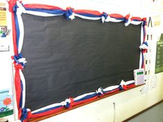 a blackboard with red, white and blue strips on it in front of a wall