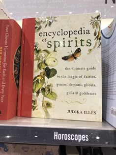 two books are sitting on a shelf in a store, with the title encyclopedia of spirits