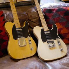 two guitars sitting on top of a couch