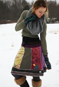 a woman standing in the snow wearing boots