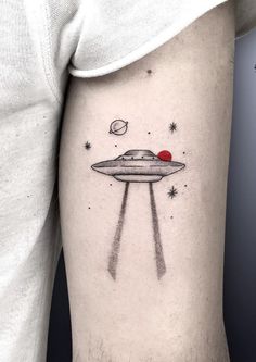 an alien ship tattoo on the left thigh