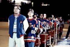 a group of men standing next to each other on top of a hockey field at night