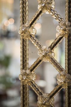 a close up view of a metal structure with rope and glass beads on the top