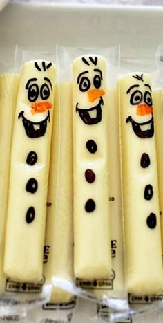 four frozen food sticks with faces and noses on them in plastic wrappers lined up next to each other