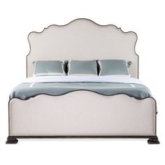 a white bed with two pillows on top of it