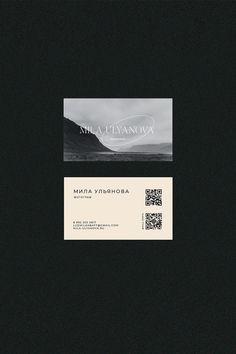 a black and white business card with an image of the mountains in the back ground