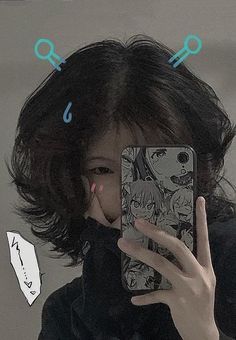 a woman taking a selfie in front of a mirror with anime drawings on it