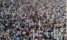 a large group of people standing in the middle of a field