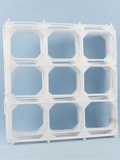 a white plastic block with several holes in the center on a light blue background that appears to be empty