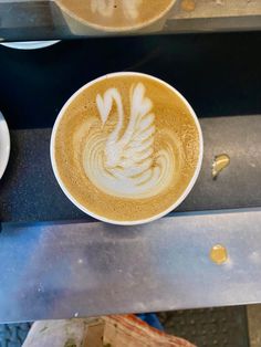 there is a cup of coffee with white designs on it and some other food items