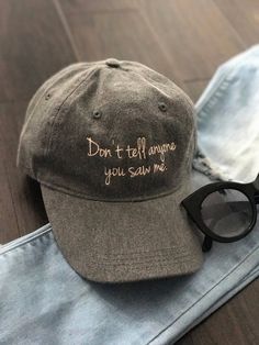 "Don't Tell Anyone You Saw Me." Baseball HatPeach thread embroidered. One size fits all with adjustable straps. Trendy Cotton Baseball Cap With Flat Brim, Trendy Flat Brim Cotton Baseball Cap, Trendy Cotton Flat Brim Baseball Cap, Trendy Cotton Trucker Hat With Flat Brim, Trendy Trucker Hat With Letter Embroidery, Casual Trucker Hat With Letter Print And Flat Brim, Casual Trucker Hat With Letter Print, Gray Cap With Embroidered Logo, Casual Trucker Hat With Letter Print For Winter