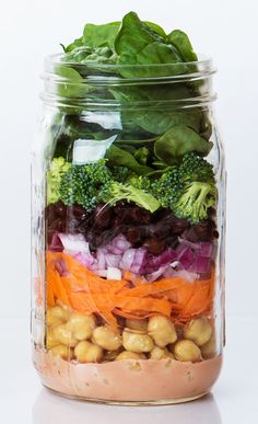 a mason jar filled with vegetables and beans