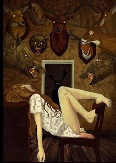 a woman laying on top of a chair in front of deer heads