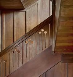 wooden stairs with decorative handrails and wood paneling