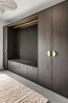 a large wooden closet with drawers and lights on the wall above it, along with an area rug