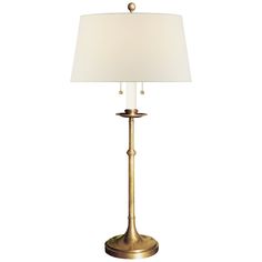 a gold lamp with a white shade on it