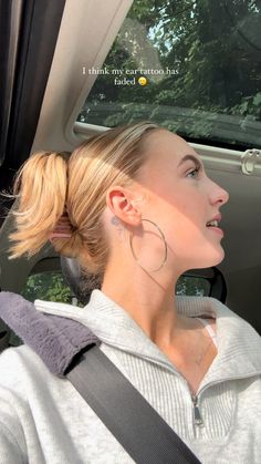 Rose tattoo behind ear
Gold hoop earrings 
Pink claw clip hairstyle 
Blonde highlights 
Side profile 
Fluffy seatbelt covers Rose Ear Tattoo, Behind The Ear Tattoo Ideas, Tattoo Behind Ear, Tattoo 2024, Dainty Tattoos, Aesthetic Iphone, Rose Tattoos