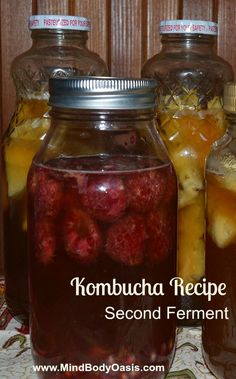 three jars filled with raspberries sitting on top of a table