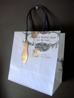 a paper bag with a gold spoon hanging from it