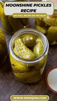 jars filled with pickles sitting on top of a wooden table