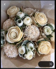 a bunch of flowers sitting on top of a table next to a cell phone screen